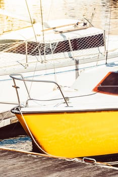 Sailboats moored in sunny marina with vibrant yellow hulls, creating a nautical background, 