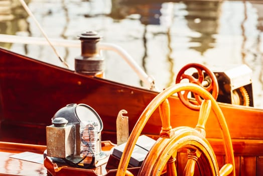 Wooden boat steering wheel and ship details creating nautical atmosphere, 