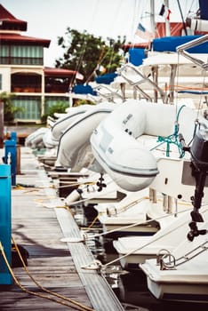 Sailboats moored at marina with inflatable dinghies, nautical theme, background, 