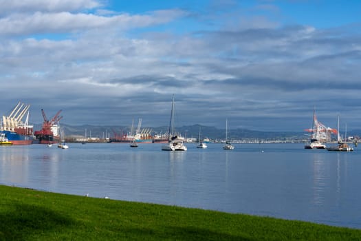Tauranga New Zealand - June 26 2023; View from Pilot Bay of both sides of Port of Tauranga facilities and boats in harbour