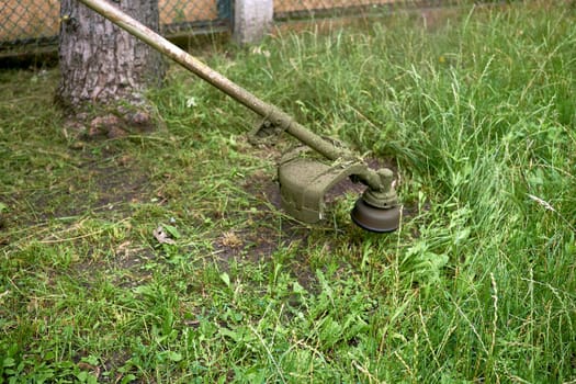 a handle electric or gasoline machine for cutting the grass on a lawn