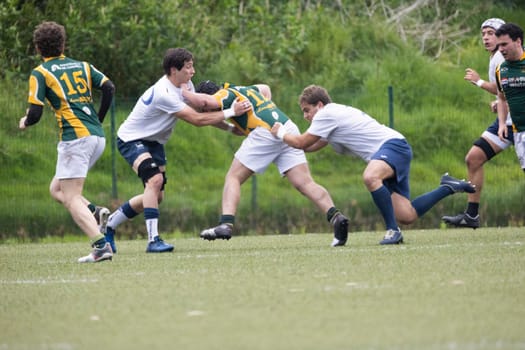 3 may 2025, lisbon. Portugal - oeiras vs ag - rugby players tackling during a rugby match on a green field