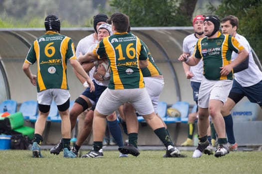 3 may 2025, lisbon. Portugal - oeiras vs ag - rugby players running with the ball and tackling during a rugby match on a green field
