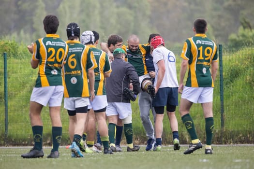 3 may 2025, lisbon. Portugal - oeiras vs ag - teammates and medical staff carrying an injured rugby player off the field during a match