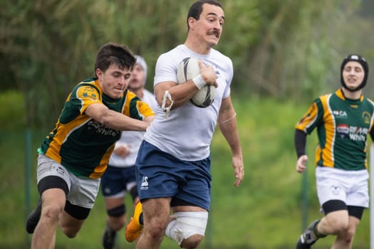 3 may 2025, lisbon. Portugal - oeiras vs ag - rugby player running with the ball and being tackled by an opponent during a competitive rugby match