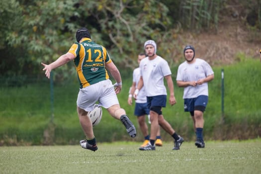 3 may 2025, lisbon. Portugal - oeiras vs ag - rugby player kicking the ball during a game, with other players in the background