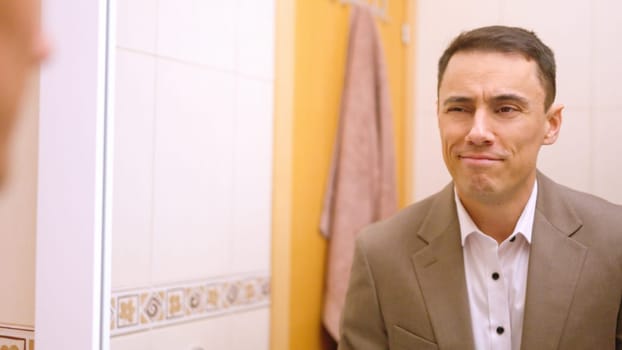 Businessman admiring himself in mirror, feeling confident and ready to start the workday