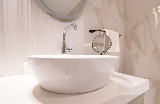 A modern white bathroom sink with chrome faucet and clean elegant interior.
