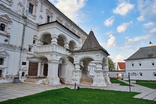 Exterior view of a historic white building with ornate columns and an arched porch
