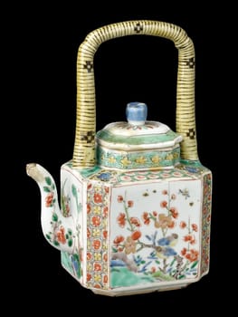 Detailed antique Chinese teapot with an octagonal body and lid, dating from the Qing Dynasty. Features colorful floral and geometric patterns on porcelain. Represents historical Chinese artistry.
