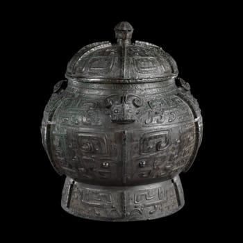 Ancient Chinese bronze Pou, a wine container from the Shang Dynasty (13th century BCE). Features intricate taotie masks and geometric patterns. Represents early Chinese ritual art and history.