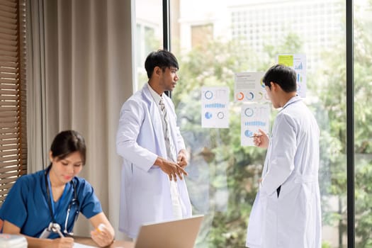 A healthcare team reviews graphs and statistics during a meeting, demonstrating strategic planning and teamwork in a contemporary office.