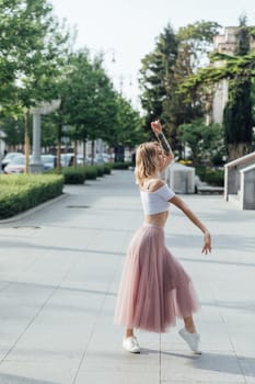 Blonde in dress dancing to music on city street