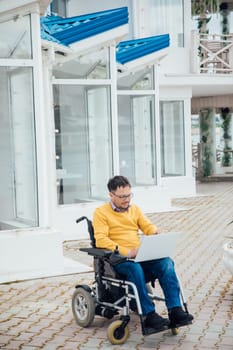 Man in wheelchair working with laptop online negotiating business