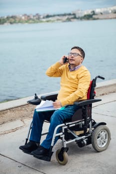 Disabled man in wheelchair wheelchair working on laptop online negotiation