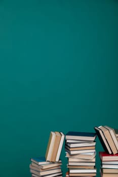 Stacks of old educational books for study in the library on a green background