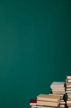 Stacks of old educational books for study in the library on a green background