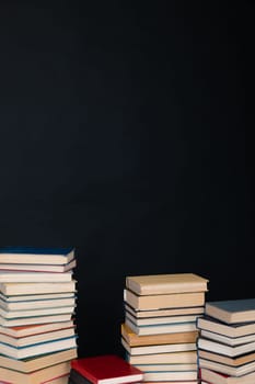 Stacks of old educational books for studying in the library on a black background of the university
