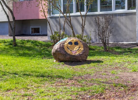 Smiley face painted in the large stone outdoors