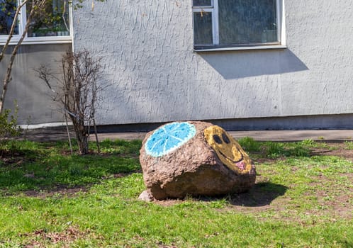 Smiley face painted in the large stone outdoors