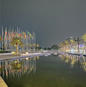 Flags of different countries are fluttering in the wind at the Flags Square in Doha in the evening