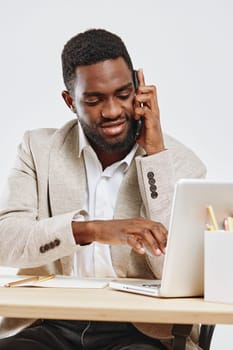 Confident professional man engaging in a business call while sitting at a clean desk with a laptop, in a well-lit modern office. Casual yet professional attire, positive mood, work-from-home or office scene. Concept: remote work, communication.