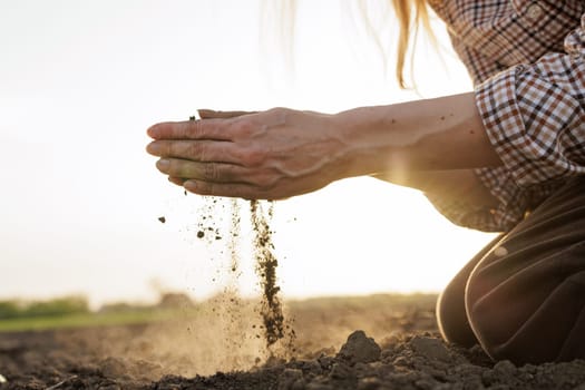 Farmer’s hands analyzing soil quality at sunset, symbolizing sustainable agriculture and land management.