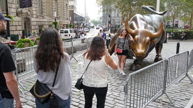 New York City, United States - 9 Sept 2023: Charging Bull, Wall street Stock Exchange symbol in USA. Lower Manhattan Downtown Financial District. American Broadway street. Tourist people photographing