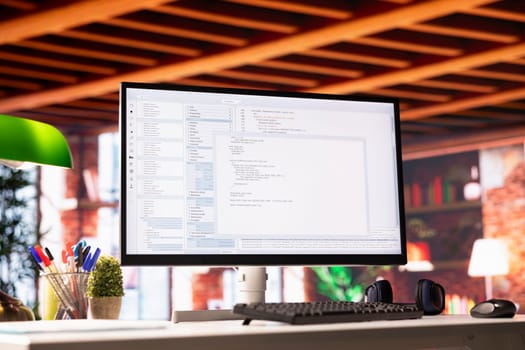 Lines of code written on PC workstation display on development tool application, close up. Debugging software programming language displayed on computer monitor in living room office