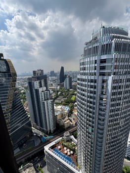 Skyscrapers towering over the Bangkok metropolis with big windows in the city center, corporate area with breathtaking engineering and infrastructure. Urban landscape in Thailand.