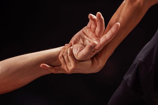 Close-up of therapist stretching a client hand and wrist during a professional physical therapy session.