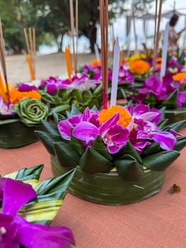 Bangkok, Thailand - November 10, 2024: Floral arrangements placed on tables, part of sacred ritual where flowers and floating candles drift on water. Devotion and blessings in a cultural ceremony.