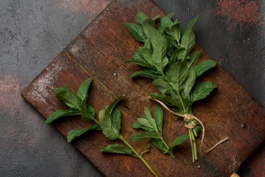 Bunch of fresh green mint on wooden board, top view. Cocktail ingredient