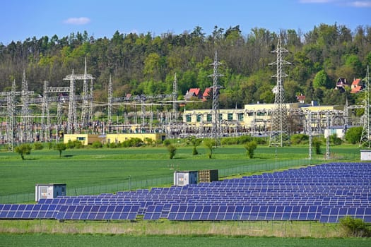 Electric power poles. Power plant - current distribution station. Concept for industry and technology with electricity.
Solar power plant -  ecological industry. Photovoltaic power plant.
