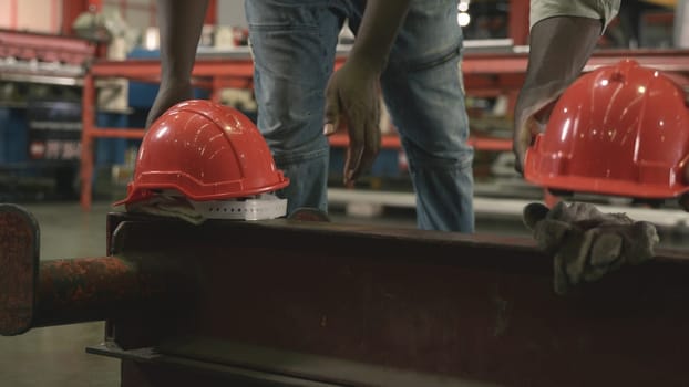 Time toget off from work. factory worker take off helmet put it on a large piece of iron, engineering in uniform walking go back to home