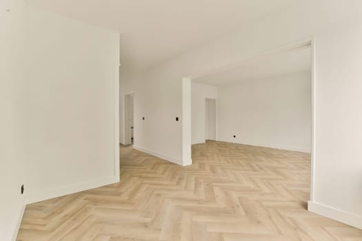 Spacious modern interior featuring light-colored walls and stylish herringbone patterned flooring, creating a contemporary and inviting atmosphere.