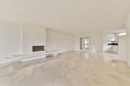 A bright and spacious living room features a sleek design with white walls, smooth flooring, and a modern fireplace, creating a tranquil atmosphere for relaxation.