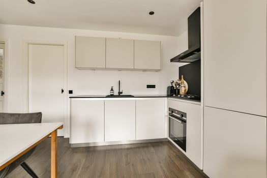 A sleek and functional kitchen featuring a modern design with white cabinetry and contemporary appliances, creating an organized cooking space.