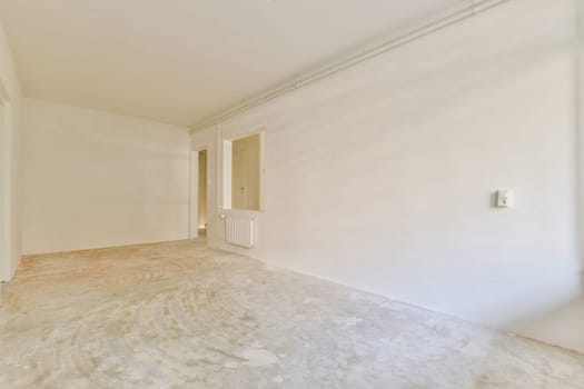 A spacious, undecorated room with plain white walls and a bare floor, ready for interior design or renovation. Ideal for inspiration in minimalist aesthetics.