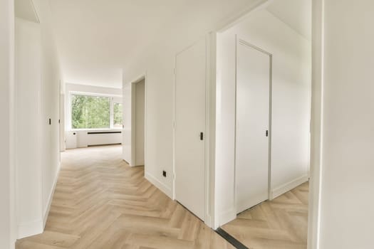 A bright and spacious hallway featuring light-colored walls and wooden flooring. Natural light streams through the windows, creating an inviting atmosphere.