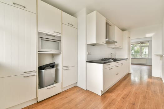A sleek, modern kitchen showcasing minimalist design with white cabinets, stainless steel appliances, and a spacious layout for cooking and dining.