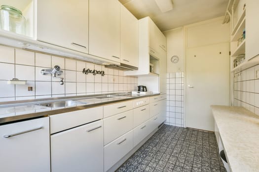 A contemporary kitchen featuring sleek white cabinetry, stainless steel appliances, and minimalist design, showcasing a clean and functional space for cooking.