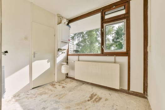 A spacious, modern room featuring large windows, neutral walls, and a minimalist design, allowing ample natural light to create an inviting atmosphere.