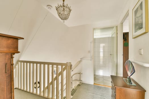 A beautifully designed staircase leading to a welcoming space, highlighted by a sparkling chandelier and minimalist decor.