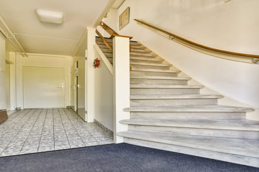 A contemporary staircase featuring plush carpeting and a minimalist handrail, leading to a light-filled upper level in a stylish interior.