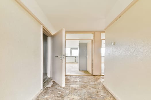 An airy interior hallway featuring light-colored walls and multiple doorways, creating a sense of openness and spaciousness.