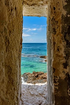Sea of ​​the city of Salvador in Bahia seen through a small window in a sentry box in the historic fort of Farol da Barra