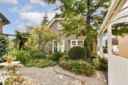 A vibrant garden featuring a variety of lush plants, shrubs, and trees, complemented by a charming modern house in the background. A perfect blend of nature and architecture.