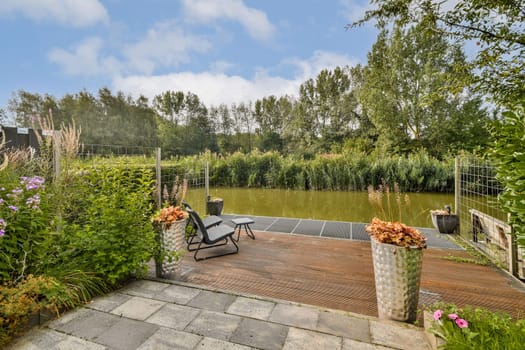 A peaceful garden scene featuring lush greenery, a calm water body, and decorative plants creating a relaxing atmosphere for outdoor enjoyment.