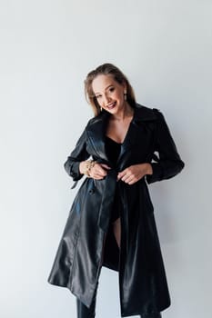 Fashionable slim woman in black leather raincoat and boots